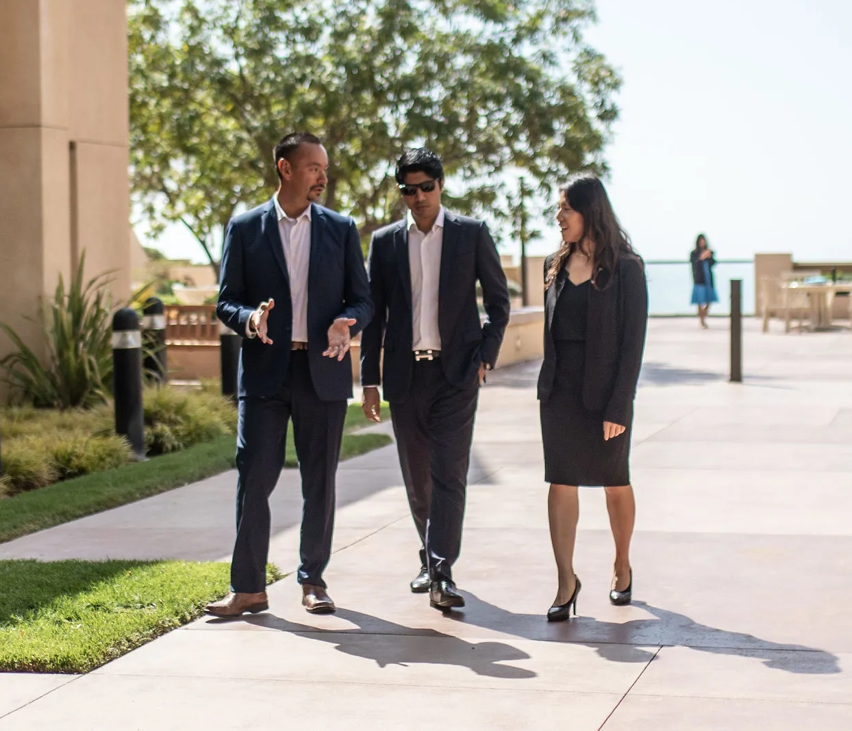 Three Pepperdine MBA colleagues meet outside an office building.
