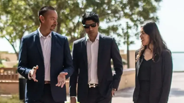 Three Pepperdine MBA colleagues meet outside an office building.